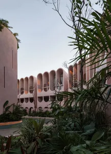 A large hotel building with a pink and white exterior, surrounded by palm trees, creating a tropical ambiance and inviting atmosphere