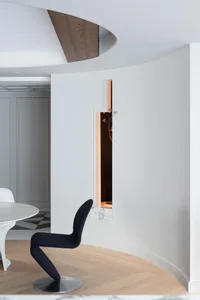 Minimalist interior design concept with a white wall, doorway, chair, and table, giving a clean and bright appearance