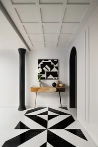 Stylish living space with a black and white checkered floor, vases, a potted plant, and inviting atmosphere