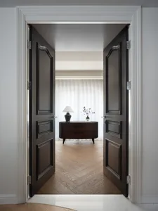Warm and inviting living area with hardwood flooring, a wooden dresser, and vases, creating a cozy ambiance