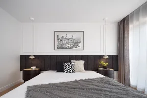 Cozy bedroom with a large bed, a chair, and a painting above the bed