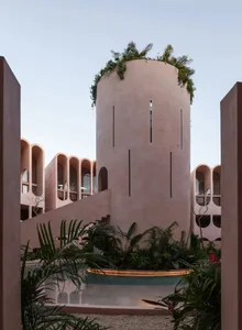 A modern building with multiple levels, featuring a mix of concrete, stone, and wood materials, with ample natural light from windows on each level