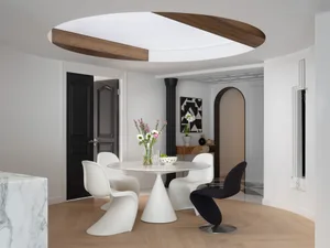 Open living area with a dining table, white walls, and a couch, creating a clean and bright atmosphere for relaxation and socializing