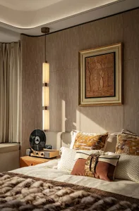 A warm and inviting bedroom with a large bed, artistic painting, and brown throw pillows