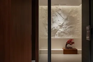 A clean and organized entryway with a wooden doorway, a rock wall, and decorative vases, creating a sense of orderliness