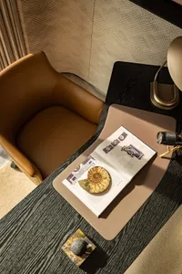 Cozy study with a brown leather chair and wooden table, featuring a book with a cake on its cover
