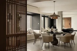 Elegant open concept dining area with a wooden dining table and chairs, wine glasses, and a warm atmosphere