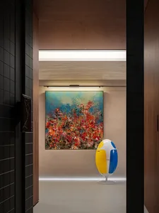 A warm and inviting living area with a beach scene painting on the wall, accompanied by two vases and a chair, creating a cozy atmosphere
