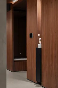 A dark hallway with wooden walls and floors, featuring two doors and a gloomy atmosphere