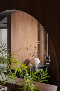Interior space with wooden walls, a wooden cabinet, potted plants, and a decorative vase