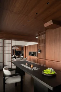 A modern kitchen and dining area with wooden walls and floors, featuring a dining table and chairs, and a sink near one of the walls