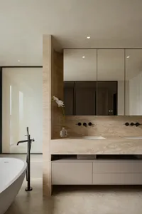 Double sink bathroom with two toilets, mirrors, and a luxurious interior