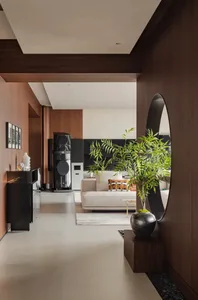 Open concept living and dining area with modern furniture, a TV, and a potted plant, surrounded by well-lit walls and a dining table with chairs
