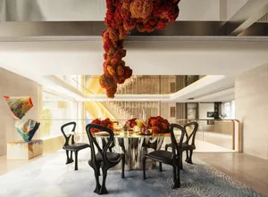Cozy dining area with a modern dining table, chairs, and decorative vases, surrounded by natural light from windows