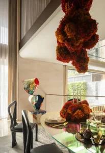 Dining area with a wooden table and chairs, surrounded by vases and decorative elements, creating an elegant and welcoming atmosphere