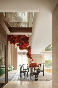 Inviting open concept living area with a dining table, couch, and decorative elements such as potted plants, vases, and flowers