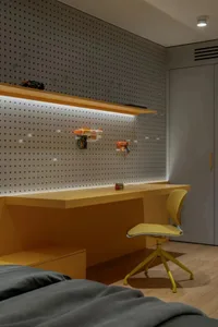 A well-lit room with a yellow desk, two chairs, and a playful atmosphere
