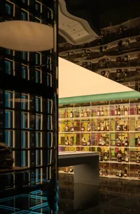 A well-lit bar filled with various liquor bottles on display, creating a visually appealing arrangement in a cozy and inviting atmosphere