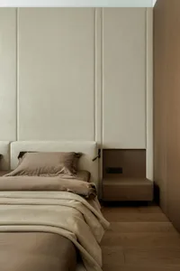 A warm and inviting bedroom with a large bed on a wooden floor, surrounded by two pillows and a cozy atmosphere