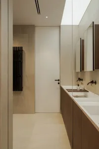 Bathroom with two sinks, tile walls, and dim lighting creating a cozy atmosphere