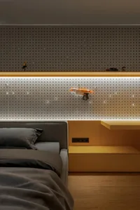 A casual bedroom with a bed, couch, and bulletin board featuring toys and objects, creating a comfortable atmosphere