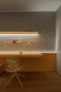 A casual office space with two chairs and orange wall-mounted guns, featuring a relaxed atmosphere