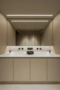A modern bathroom with a white sink, two faucets, and a clean, well-lit atmosphere