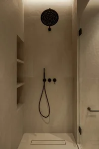 A modern bathroom with a white bathtub and two shower heads, set against a backdrop of tile-walled surfaces