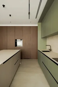 A modern kitchen with green walls, wooden cabinets, and a clean, well-organized layout featuring a sink, oven, and refrigerator, with two sinks and ample space