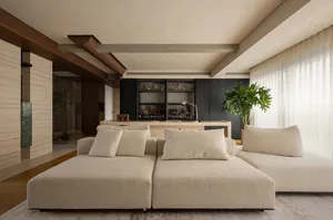 Open living area with two couches, chairs, and natural/artificial lighting, featuring modern and contemporary design elements