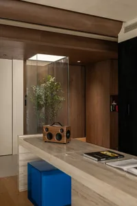 Cozy modern living space with a wooden cabinet, speakers, and natural light from windows