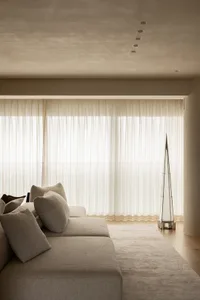 A bright and inviting living room with white furniture, large windows, and a clean atmosphere