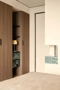 A wooden cabinet with a marble countertop, two lamps, and a well-lit room