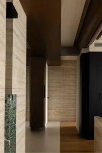 Modern bathroom with a brown wooden door, white tiled wall, and two sinks, featuring a clean and well-organized atmosphere