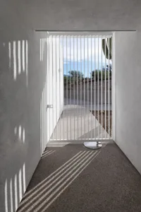 A patio area with a dining table and metal gate, creating a welcoming outdoor space for socializing and relaxation