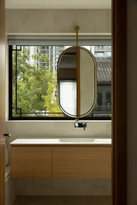Bathroom with two sinks, a mirror, and a window, featuring a wooden theme and natural light