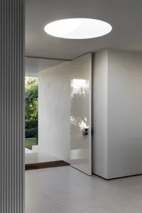 Bright and inviting interior space with a glass door, two potted plants, and natural light