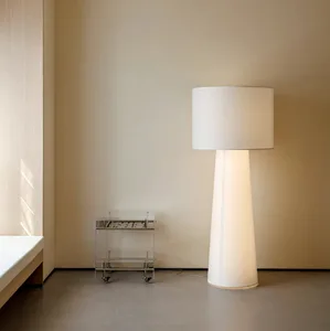 A minimalist living area with a metal lamp, a large window, and natural light