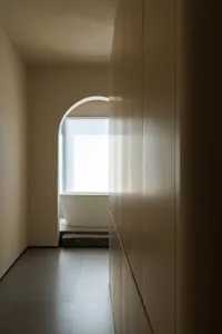 A calm and quiet empty hallway with a white wall and two windows on either side