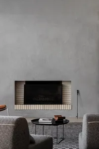 Cozy living space with a brick fireplace, two couches, a chair, and a book, creating a warm and inviting atmosphere