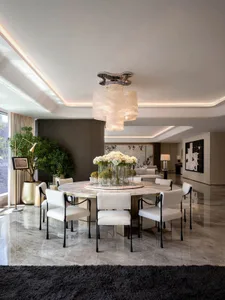 Sophisticated dining space with a large table, potted plants, and a modern chandelier