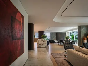Open living area with hardwood floors, multiple seating options, and decorative elements like potted plants and vases, set in a clean and contemporary design