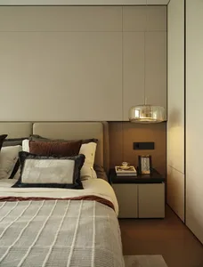 Cozy bedroom with a large bed, white bedding, and two lamps, set against a gray wall with brown accents