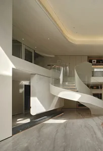 Open modern living space with a glass spiral staircase, minimalist design, and an airy atmosphere