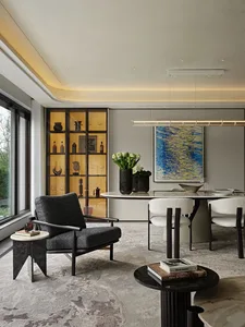 Modern living room with a large window, two chairs, a dining table, and decorative vase