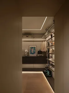 Interior hallway with a large closet containing handbags, a suitcase, and clocks, in an organized and functional space