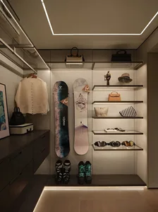 A well-organized closet with shoes, handbags, and a snowboard, showcasing a functional and stylish storage solution