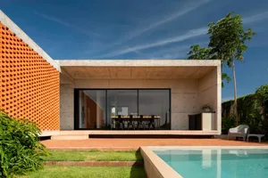 A modern living space with a large dining table, wooden chairs, and white walls, creating a cozy atmosphere for meals and gatherings