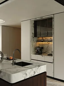 Modern kitchen with a marble countertop, sink, refrigerator, and microwave, featuring a clean and sophisticated design