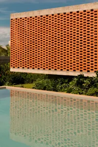 A photo of an orange wall with a pattern of squares, surrounded by potted plants in a relaxing and inviting environment